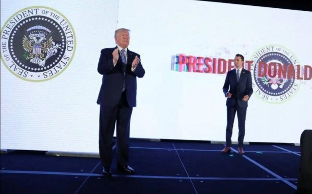 Дональд Трамп на фоне странного герба Дональд Трамп на фоне странного герба